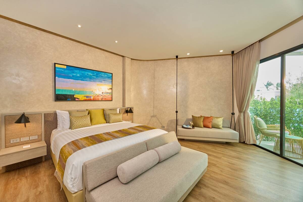 Un dormitorio moderno con una cama grande, un sofá y vistas al balcón.