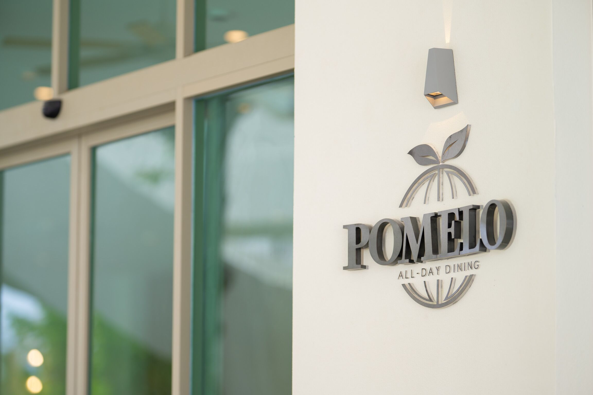 Placa para o restaurante Pomeleo All-Day Dining, com design moderno e tema de folha.