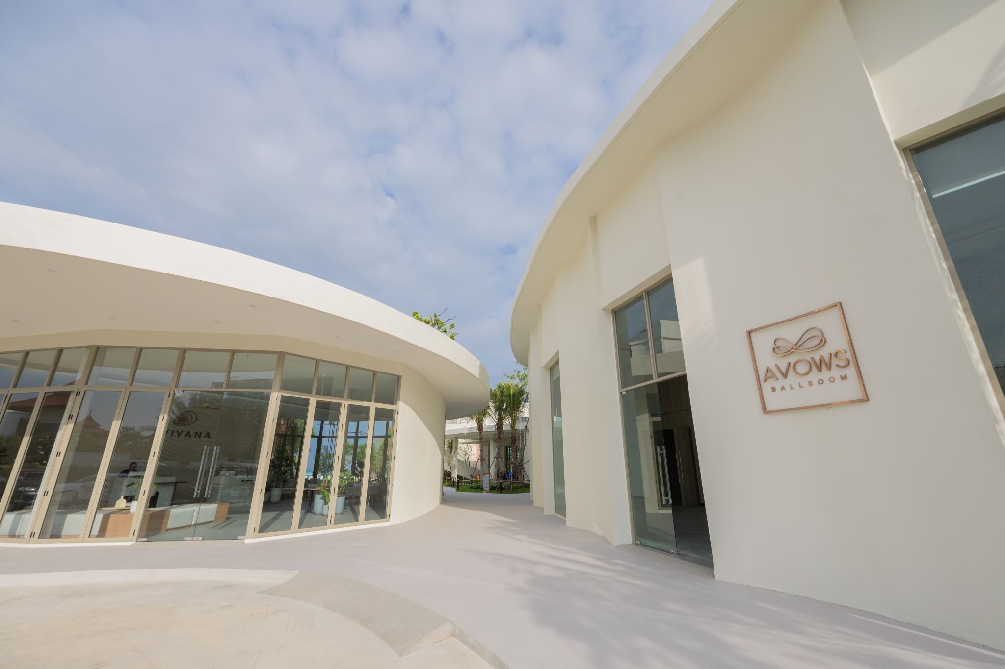 A modern building with a glass facade and a sign for "AVOWS BALLROOM".