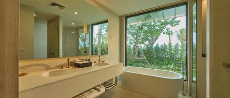 Un baño moderno con dos lavamanos, una bañera grande y un espejo amplio.