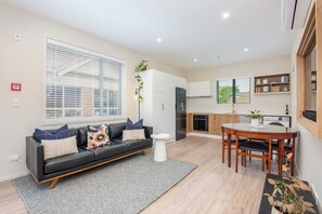 A modern apartment with a living room, dining area, and kitchen. - George Little: Stylish, Peaceful & Convenient (Dunedin)