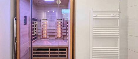 A modern room with a built-in sauna, a wooden floor, and a white radiator.