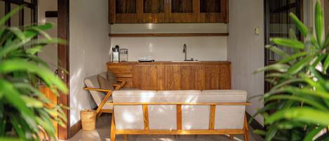 A modern kitchen with wooden cabinets, a built-in bench, and a hanging light fixture.
