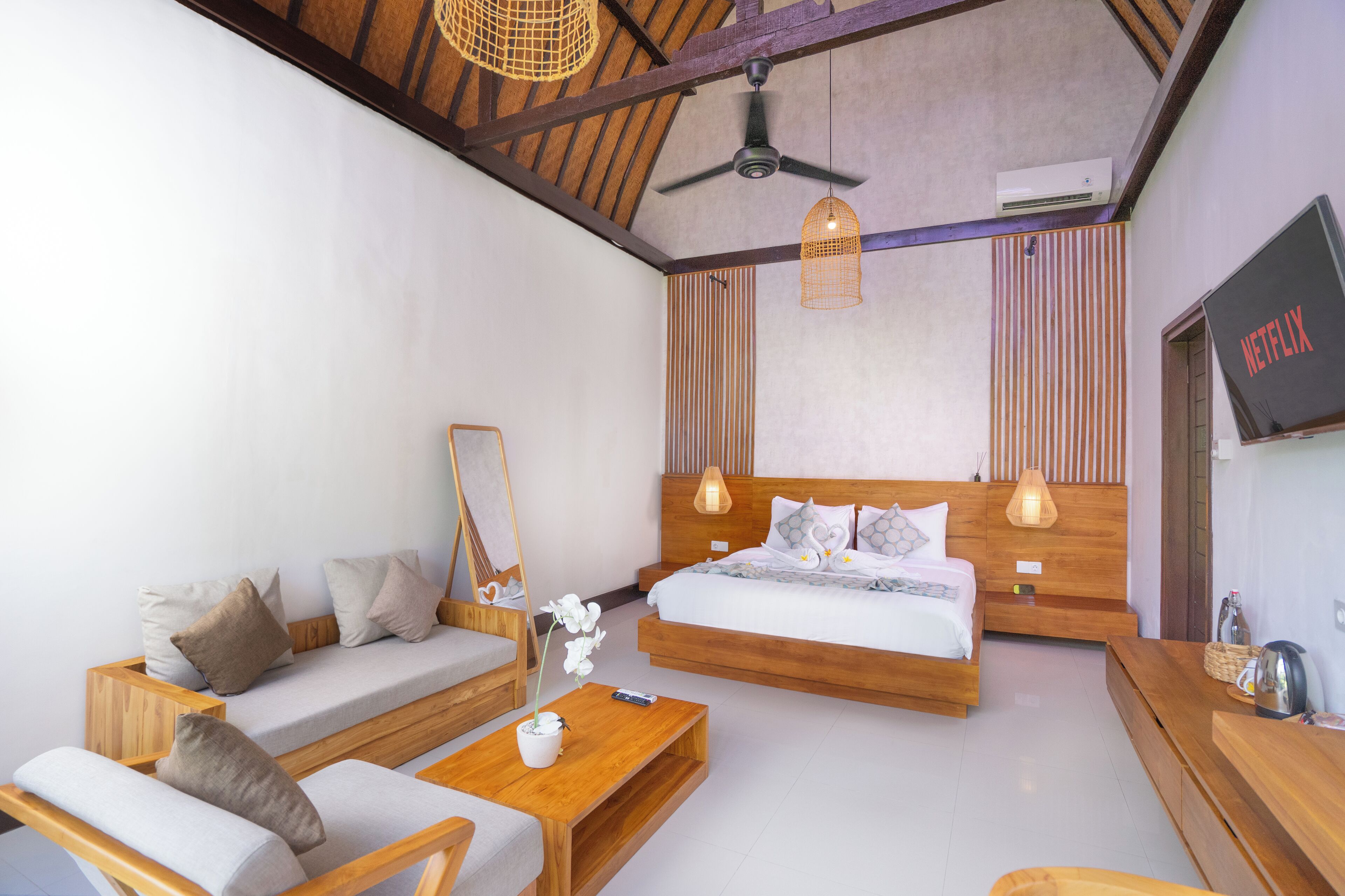 Ein modernes Schlafzimmer mit Bett, Sofa und Holzmöbeln.