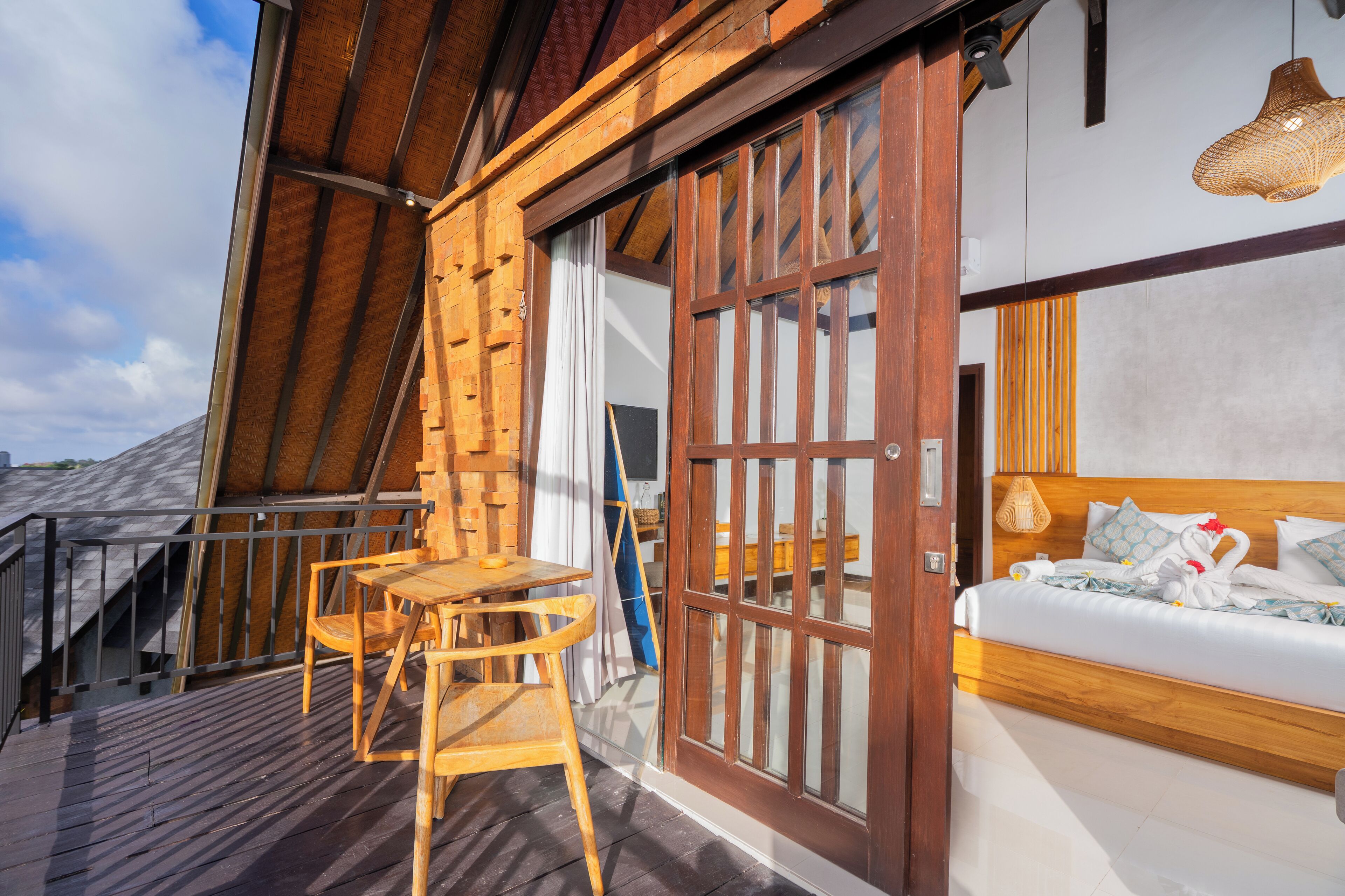 A wooden deck with a bed and a wooden chair.