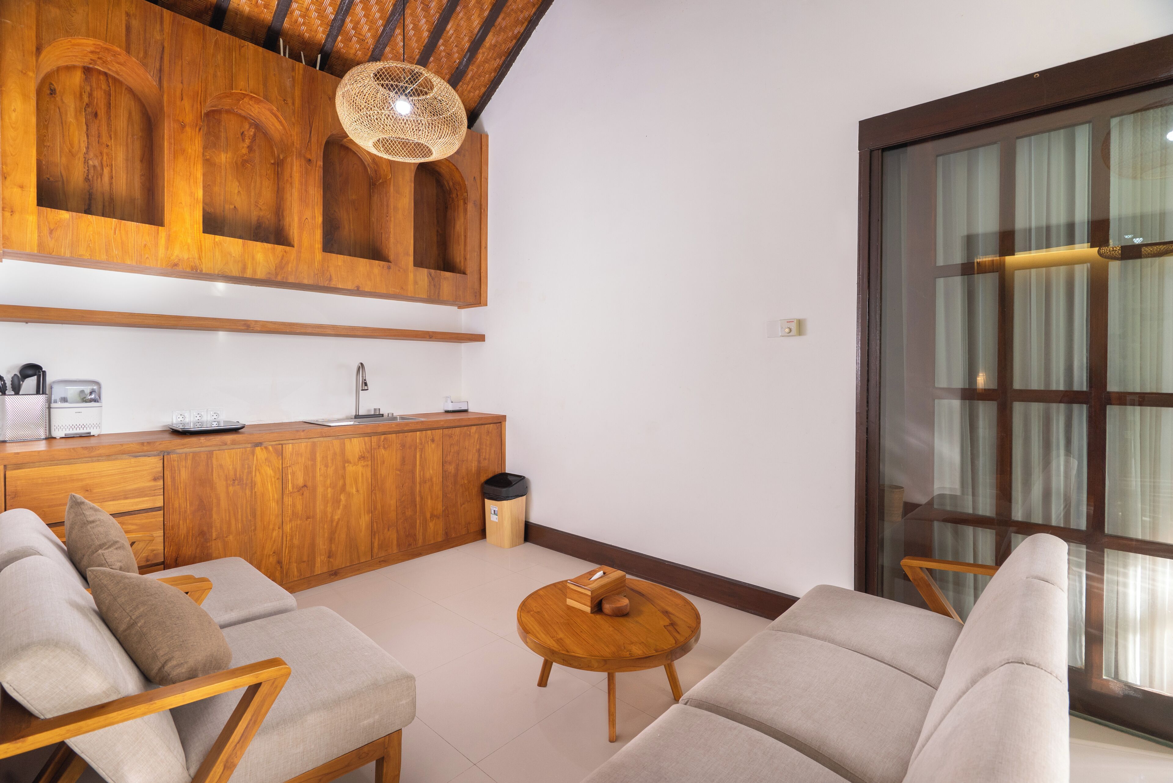 Una sala moderna con un sofá, una mesa de centro y armarios de madera.