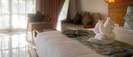 Una cama bien tendida con un plaid estampado, un cabecero de madera y una lámpara de noche.