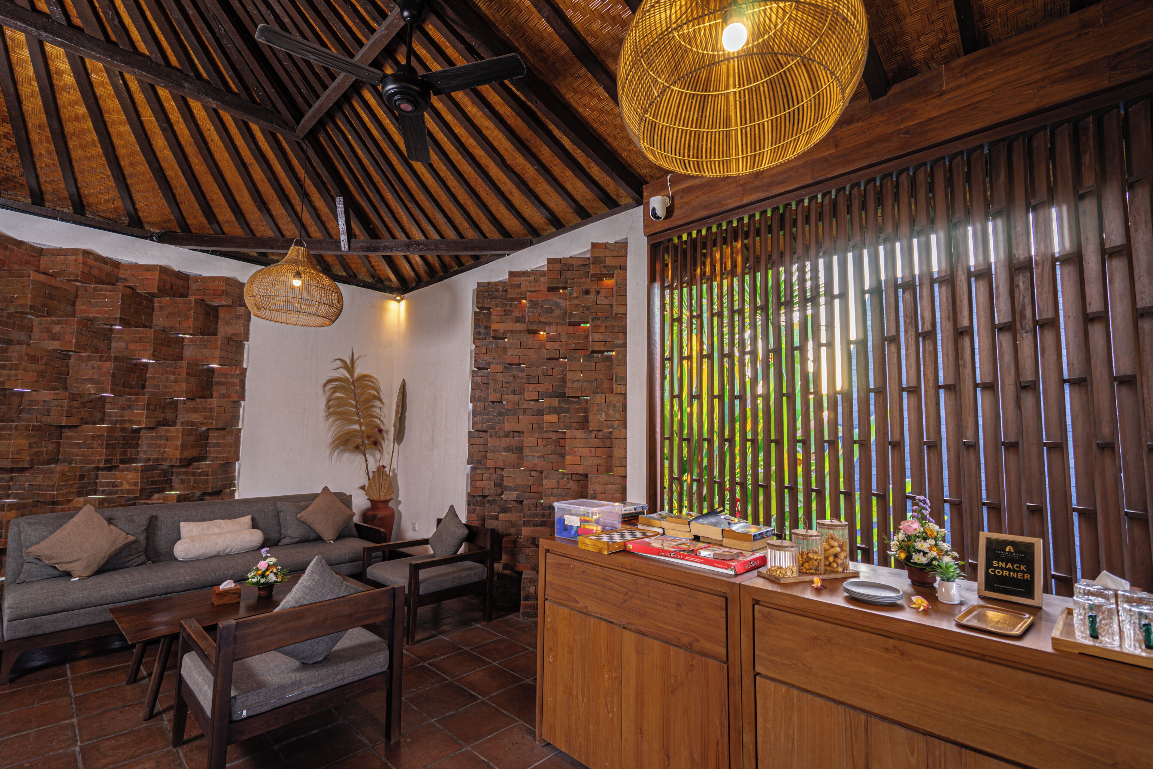 A cozy living area with a sofa, chairs, and a wooden reception desk.