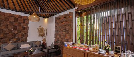 A cozy living area with a sofa, chairs, and a wooden reception desk.