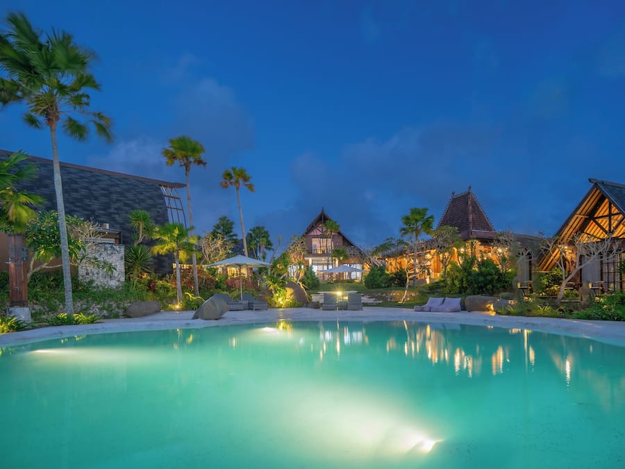 Una piscina al aire libre, sombrillas, sillones reclinables de piscina