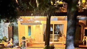 Una casa con un patio, un comedor y una cocina visibles a través de puertas de vidrio.