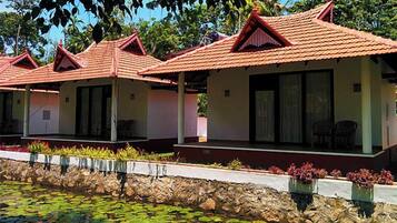 A row of bungalow-style accommodations with red-tiled roofs and large windows.