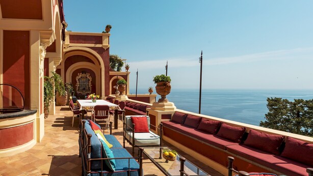 A terrace with outdoor seating, a dining area, and a view of the sea. - Palazzo San Pietro by Elite Villas (Positano)