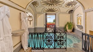 A luxurious indoor pool area with ornate ceiling designs, a stone basin, and a potted plant. - Palazzo San Pietro by Elite Villas (Positano)