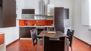 Una cocina compacta con zona de comedor, que incluye estufa, horno y muebles de cocina modernos.