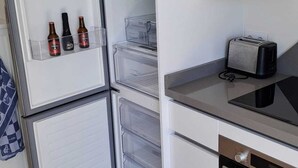 A compact kitchen with a built-in refrigerator, a toaster, and a microwave.