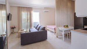 Een moderne woonkamer met een bank, een eettafel en een keukenhoek.