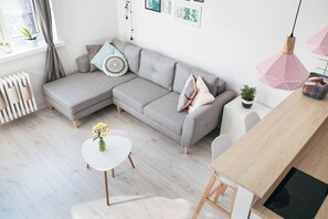 Relax in this stylish living space with a sofa, dining table, and induction cooktop.
