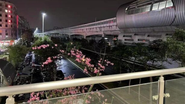 A modern building with a curved facade and a train passing by. - Shenzhen Qiaonan Hotel (Shenzhen)