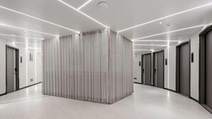 A modern hotel corridor with a central glass block structure, recessed lighting, and a polished floor. - Shenzhen Qiaonan Hotel (Shenzhen)