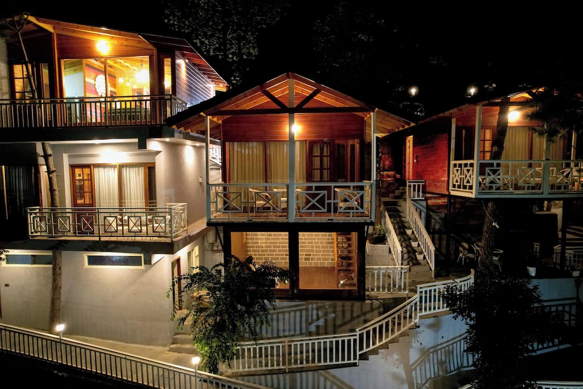 A multi-story hotel with balconies, staircases, and a well-lit exterior.