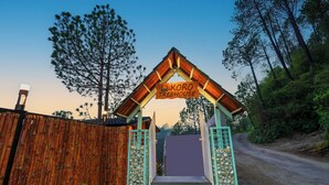 A wooden fence with a sign reading "Koro Treehouse" at the entrance. - Koro Treehouse Resort (Solan)