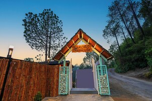 A wooden fence with a sign reading "Koro Treehouse" at the entrance.