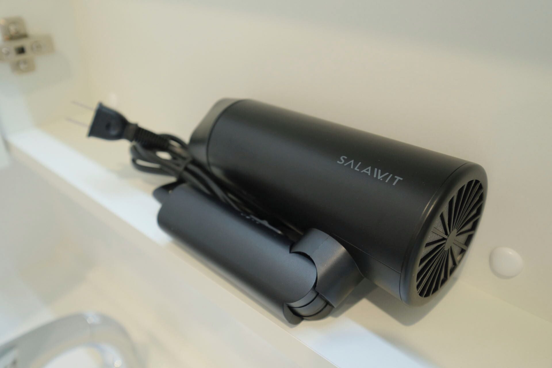 A black portable air purifier with the brand name 'SALAVIT' on a white surface.