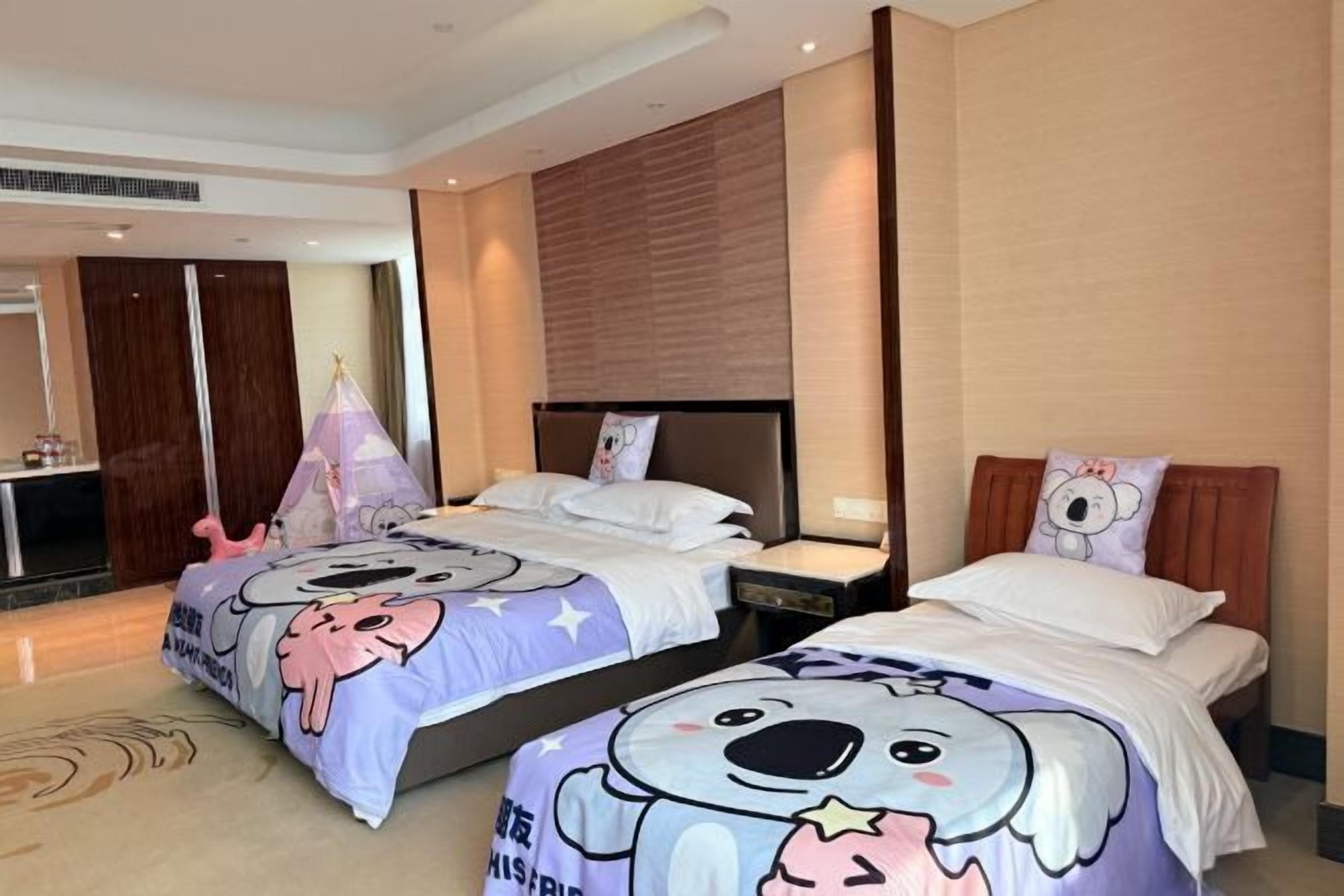 A hotel room with two beds, a wooden headboard, and a minibar.