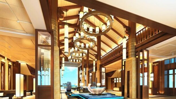Un vestíbulo amplio con una fuente central, vigas de madera e iluminación moderna.