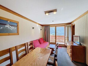 Relax in this inviting room with a dining table, sofa, and balcony offering scenic views.