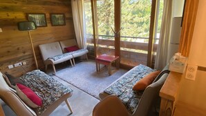 A cozy cabin-style room with a wooden interior, a sofa, a bench, and a table.