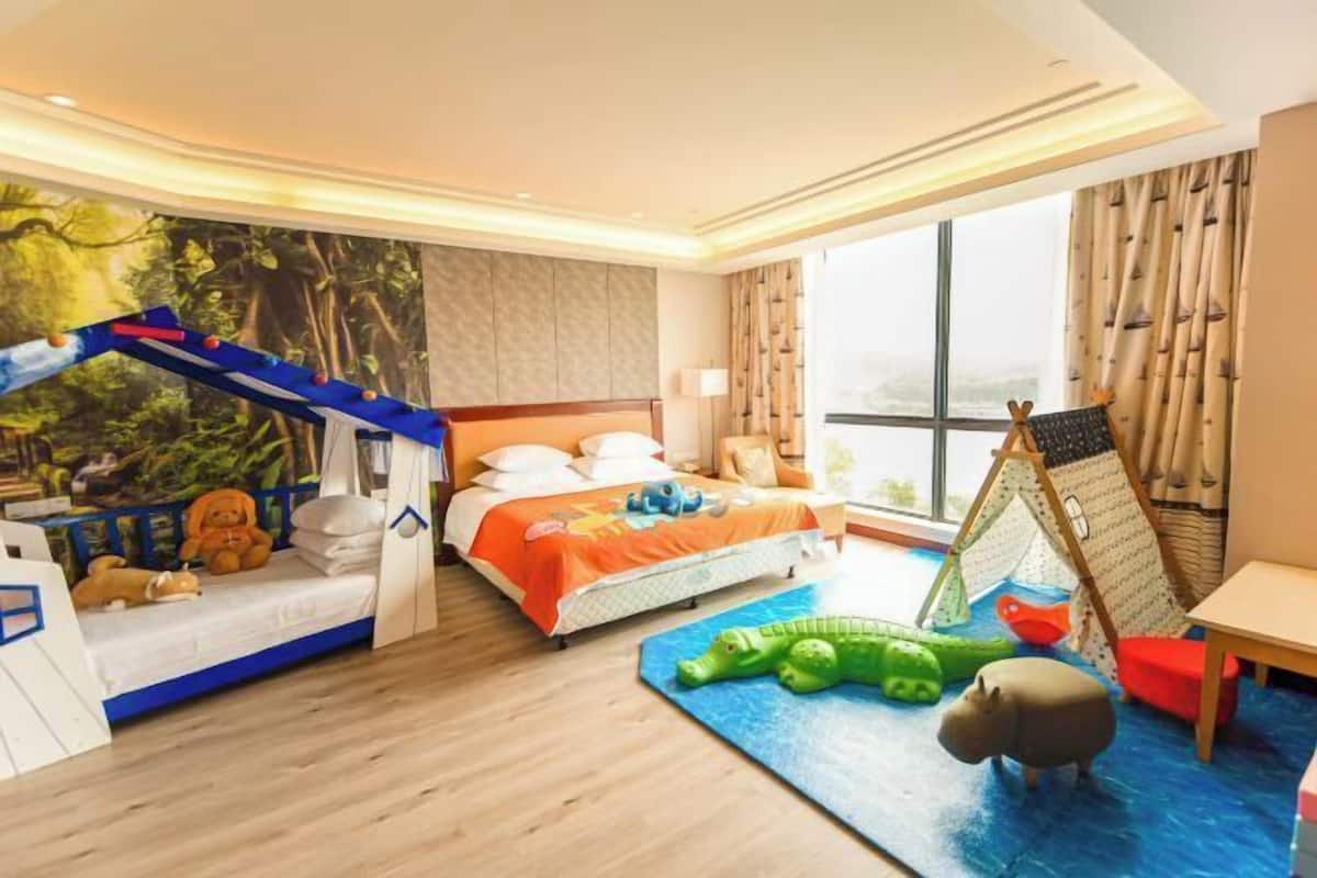 A child's room with a bed, play area, and a view of the city.