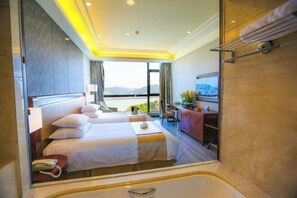A hotel room with two beds, a bathroom, a desk, and a view of the outdoors. - Grand New Century Resort Dongtou Wenzhou (Wenzhou)