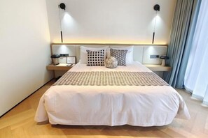 A neatly made bed with a white bedspread, two bedside tables with lamps, and a decorative vase on the bed. - Grand New Century Resort Dongtou Wenzhou (Wenzhou)
