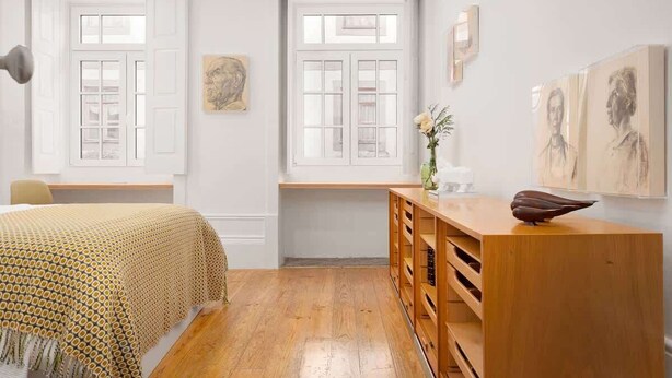 A room with a bed, wooden dresser, and two windows with white frames. - 2 Classic Apartments by HostWise (Porto)