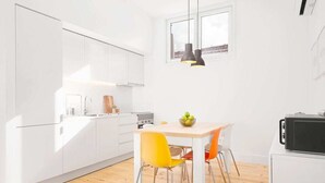 A modern kitchen with white cabinets, a wooden dining table, and two chairs.