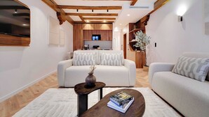 Un salon moderne avec un canapé, une table basse et un téléviseur.