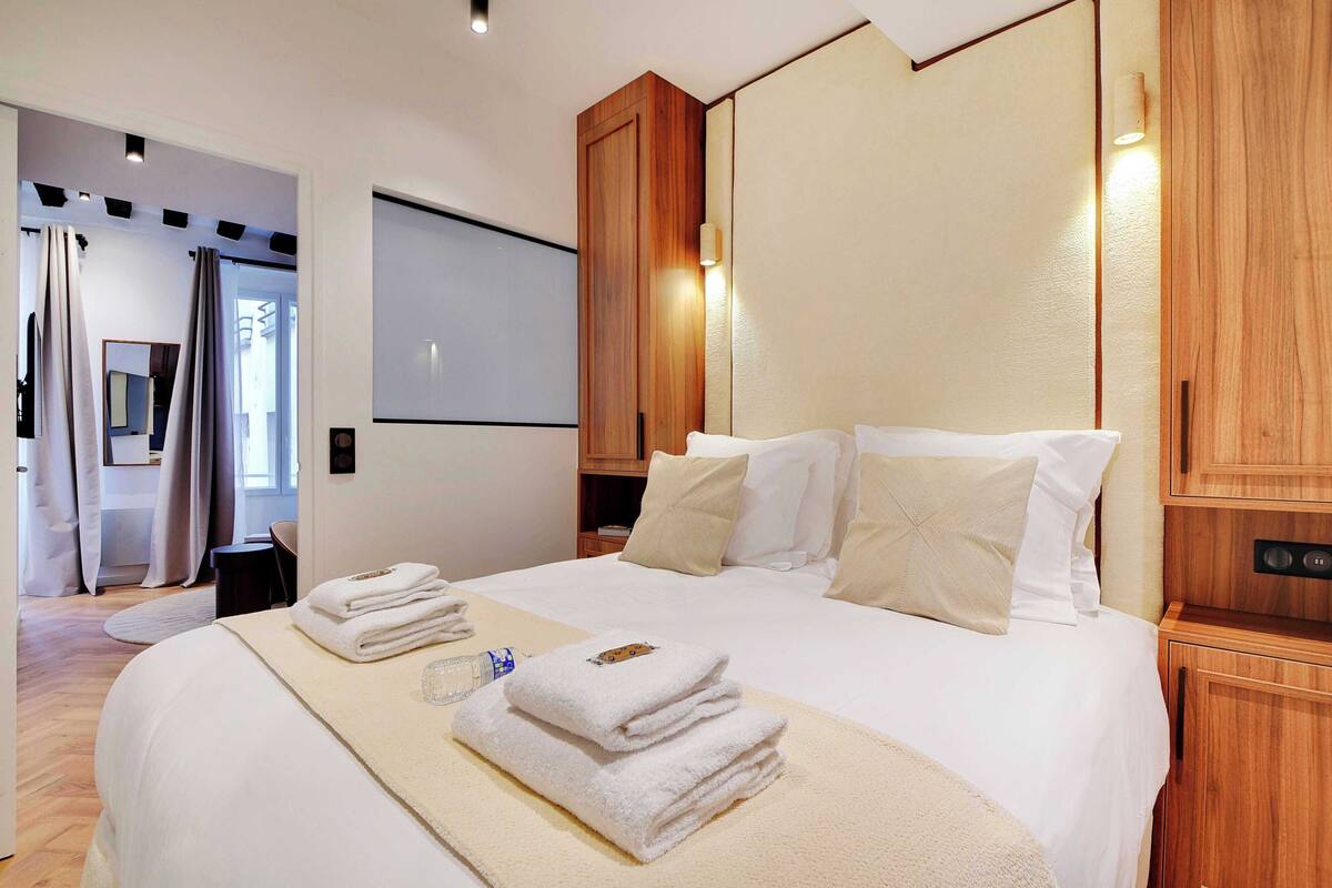 Ein Hotelzimmer mit einem großen Bett, einem Holzkopfteil und einem Flachbildfernseher.