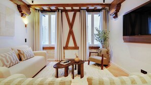 Un salon avec un plafond en bois, un canapé, une table basse et un fauteuil.