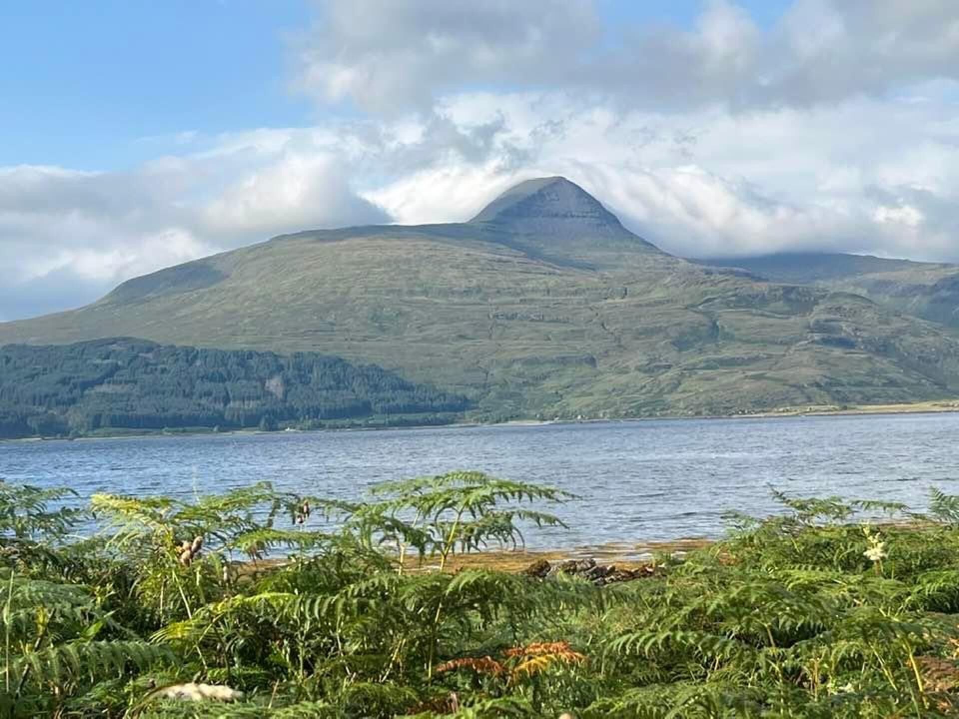 A mountain with a lake in the foreground and a clear sky.