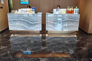 Two reception desks with marble tops and a polished black marble floor.