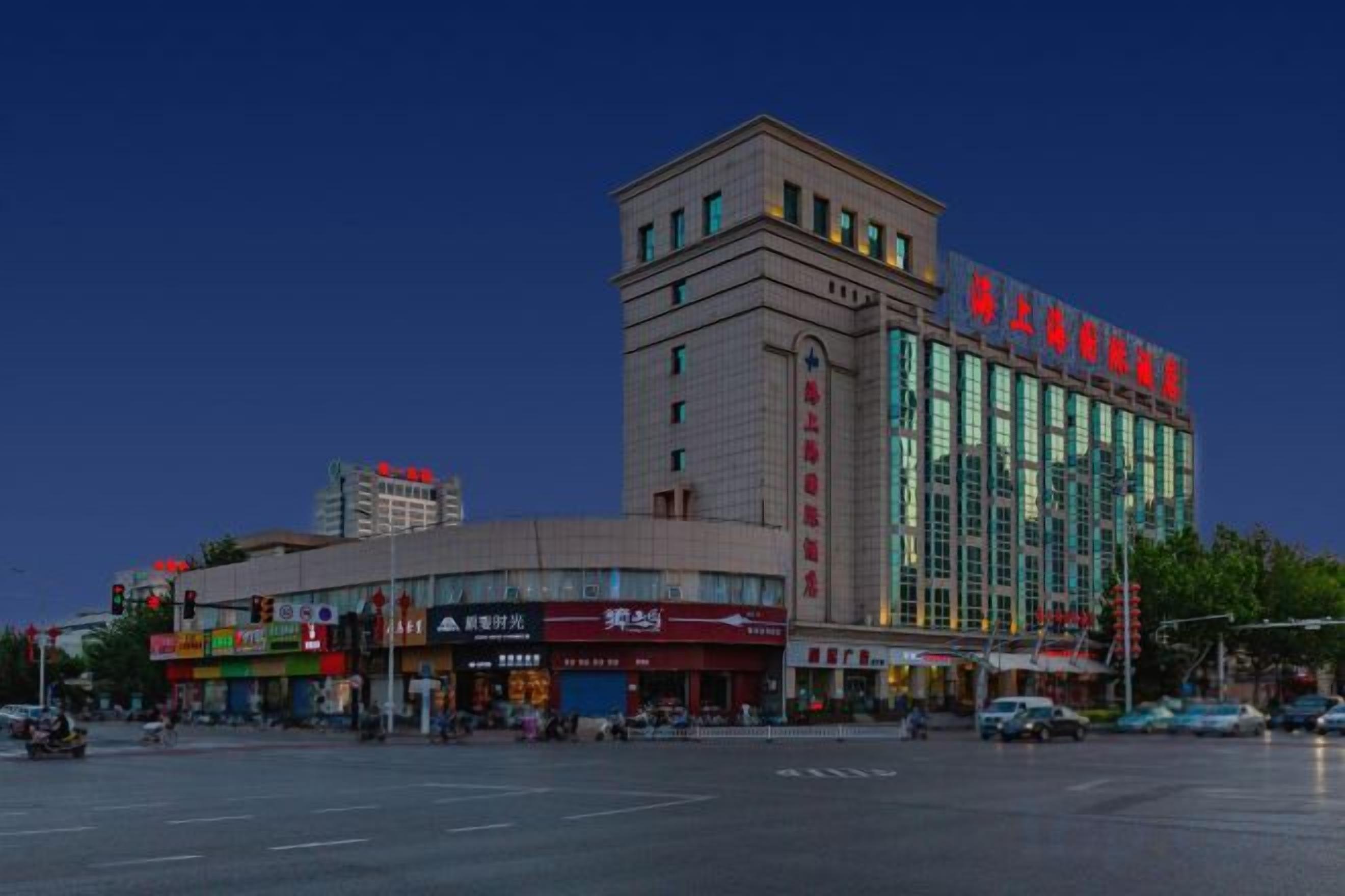 A multi-story hotel with a prominent glass facade and signage.