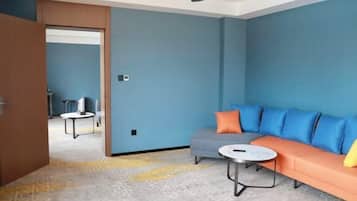 A modern living room with a sofa, a coffee table, and a patterned carpet.