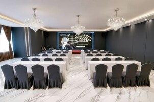 Un salón de conferencias con una larga mesa, sillas y una pantalla grande.