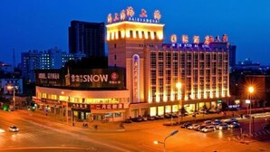 A hotel with illuminated signage, a prominent entrance, and a parking area. - Qinhuangdao Haishanghai International Hotel (Qinhuangdao)