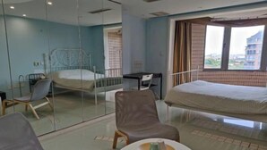 Une chambre d’hôtel avec un lit, un bureau, une chaise et une table ronde sur laquelle se trouvent une tasse et une soucoupe.