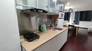Une cuisine moderne équipée d’un four à micro-ondes, d’une bouilloire et d’une plaque de cuisson à induction.