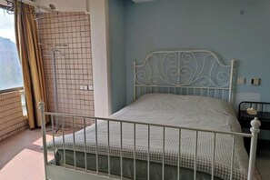 A single-bed room with a metal headboard, a checkered bedspread, a window with curtains, and a tiled wall. - iNestin Shanghai (Hongfeng Road) (Shanghai)