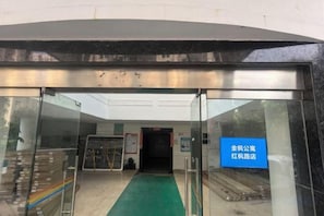 A hotel entrance with a glass door, a green carpet, and a sign indicating the hotel's name. - iNestin Shanghai (Hongfeng Road) (Shanghai)